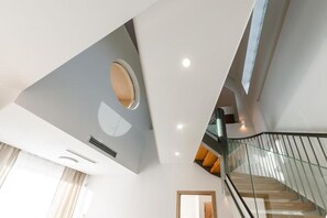 A modern interior with a staircase, a circular skylight, and a glass railing. - Chic Family Villa With Pool in Syvota (Igoumenitsa)