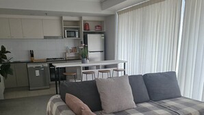 Una sala de estar moderna con un sofá, un comedor y una cocina.
