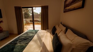 Een slaapkamer met een bed, een schilderij en uitzicht door een schuifdeur.