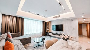 Ein modernes Wohnzimmer mit einer Sofagarnitur, einem Couchtisch, einem Fernseher und einem Kamin.