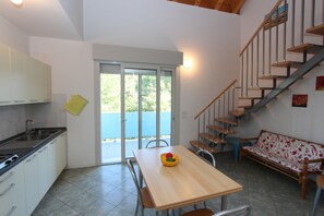 Eine Küche mit Essbereich, Treppe und einer Couch.