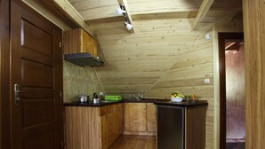 A compact kitchen with wooden cabinets, a stainless steel refrigerator, and a green dish rack. - Apartment in Lapsze Nizne With Balcony (Lapsze Nizne)