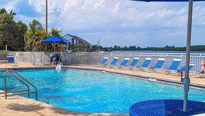 A swimming pool with blue chairs and a lifeguard stand. - Bahia Del Sol Condo (Ruskin)