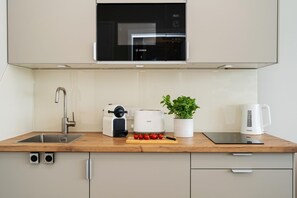 A modern kitchen with a Bosch microwave, Philips toaster, and a coffee maker on the counter. - Boje - Modern, centrally located apartment with a balcony, parking, and Wi-Fi. Pets Allowed (Sylt)