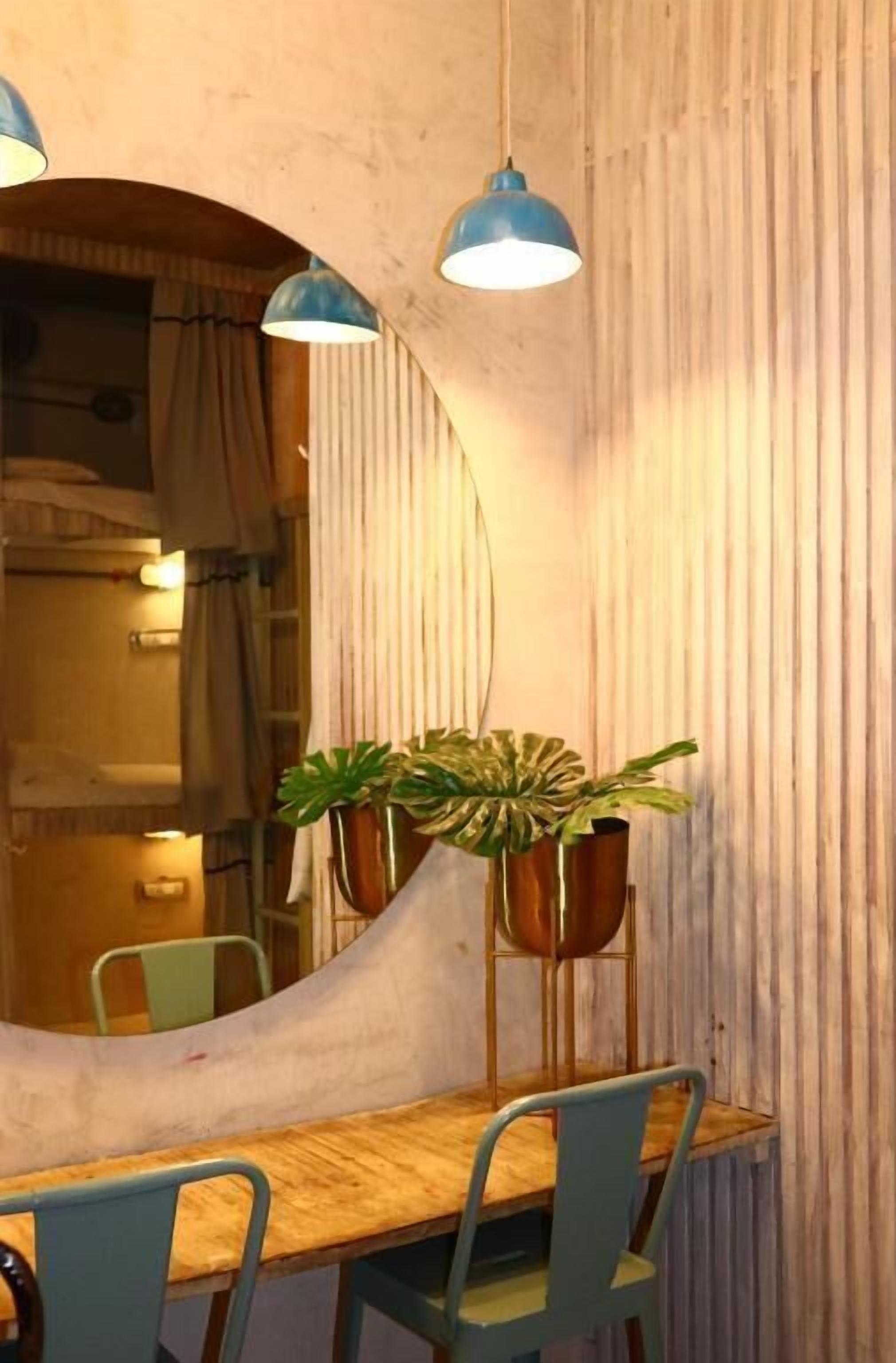 A dining area with a wooden table, blue chairs, and hanging pendant lights.