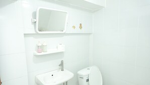 A bathroom with a toilet, sink, and mirror. - Happy Residences Pattaya 2 (Pattaya)
