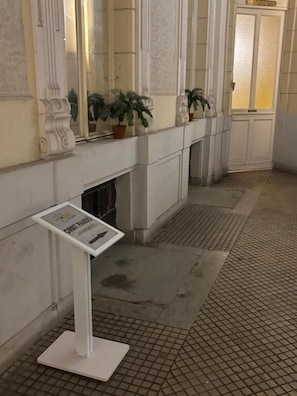 A hallway with a tiled floor, a fireplace, and potted plants.