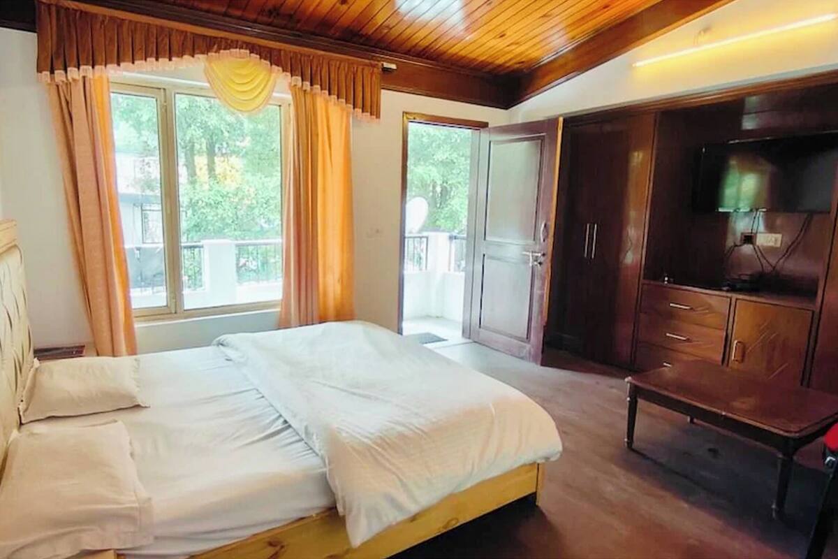 Un dormitorio con cama, armario de madera y televisor.