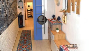 A compact kitchen with a blue partition, a small refrigerator, a wooden cabinet, and a patterned rug. - Nel Cuore del Capo  (Palermo)