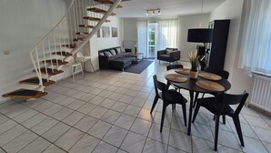 Un espace de vie moderne comprenant un escalier, un coin repas et un téléviseur.