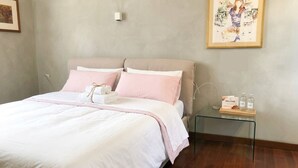 Une chambre à coucher avec un lit, une table de chevet et un tableau encadré au mur.