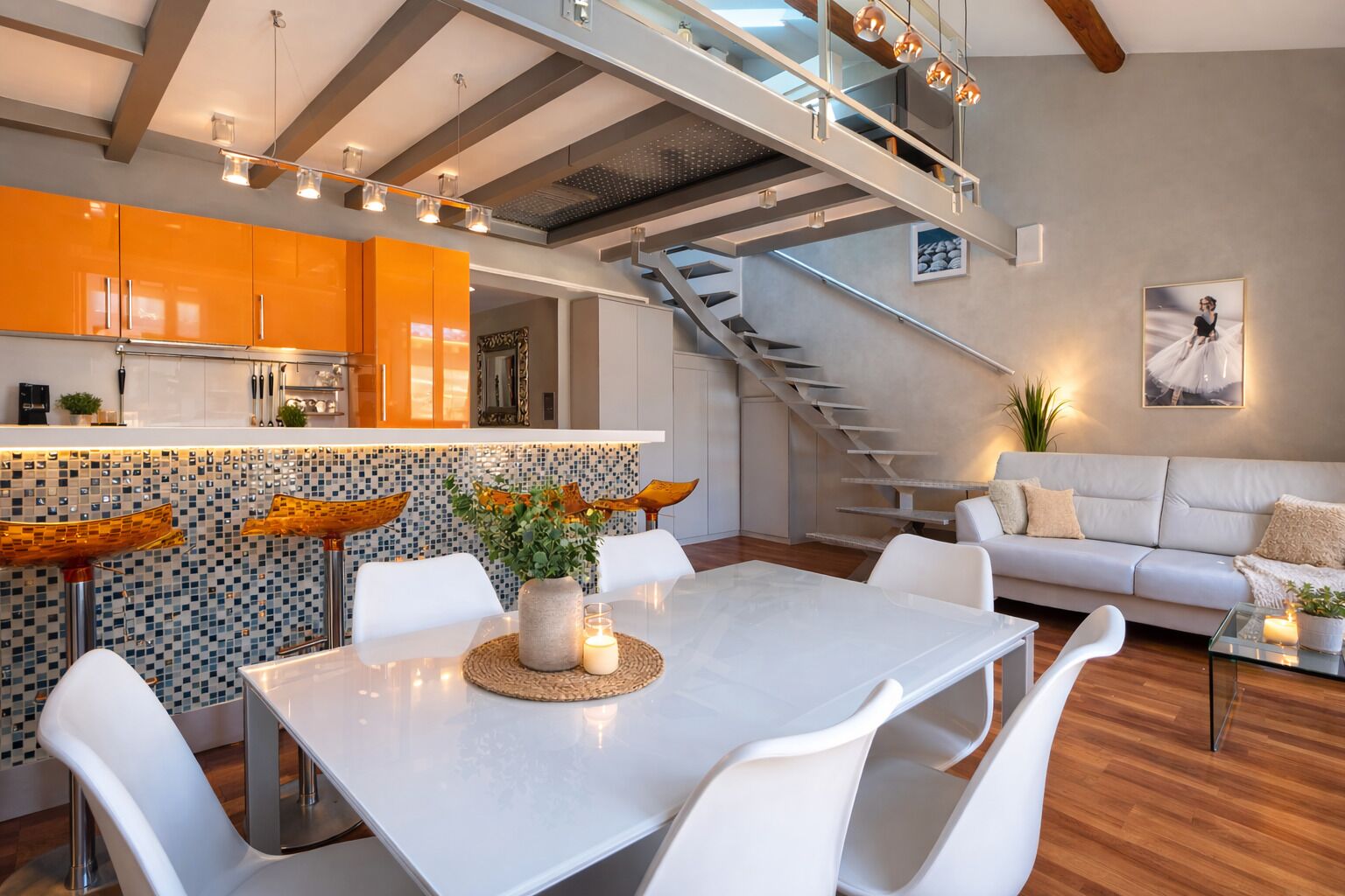 A modern interior with a dining area, kitchen, staircase, and living room.