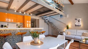 Un intérieur moderne comprenant un coin repas, une cuisine, un escalier et un salon.