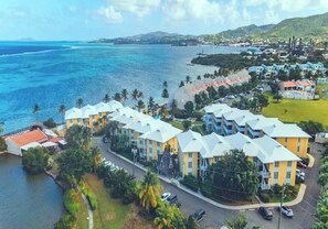 A coastal hotel with multiple buildings, a marina, and a view of the ocean.