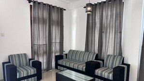 A living room with a sofa set, two armchairs, and a coffee table. - Serrena Airport Guest House - Colombo (Seeduwa)