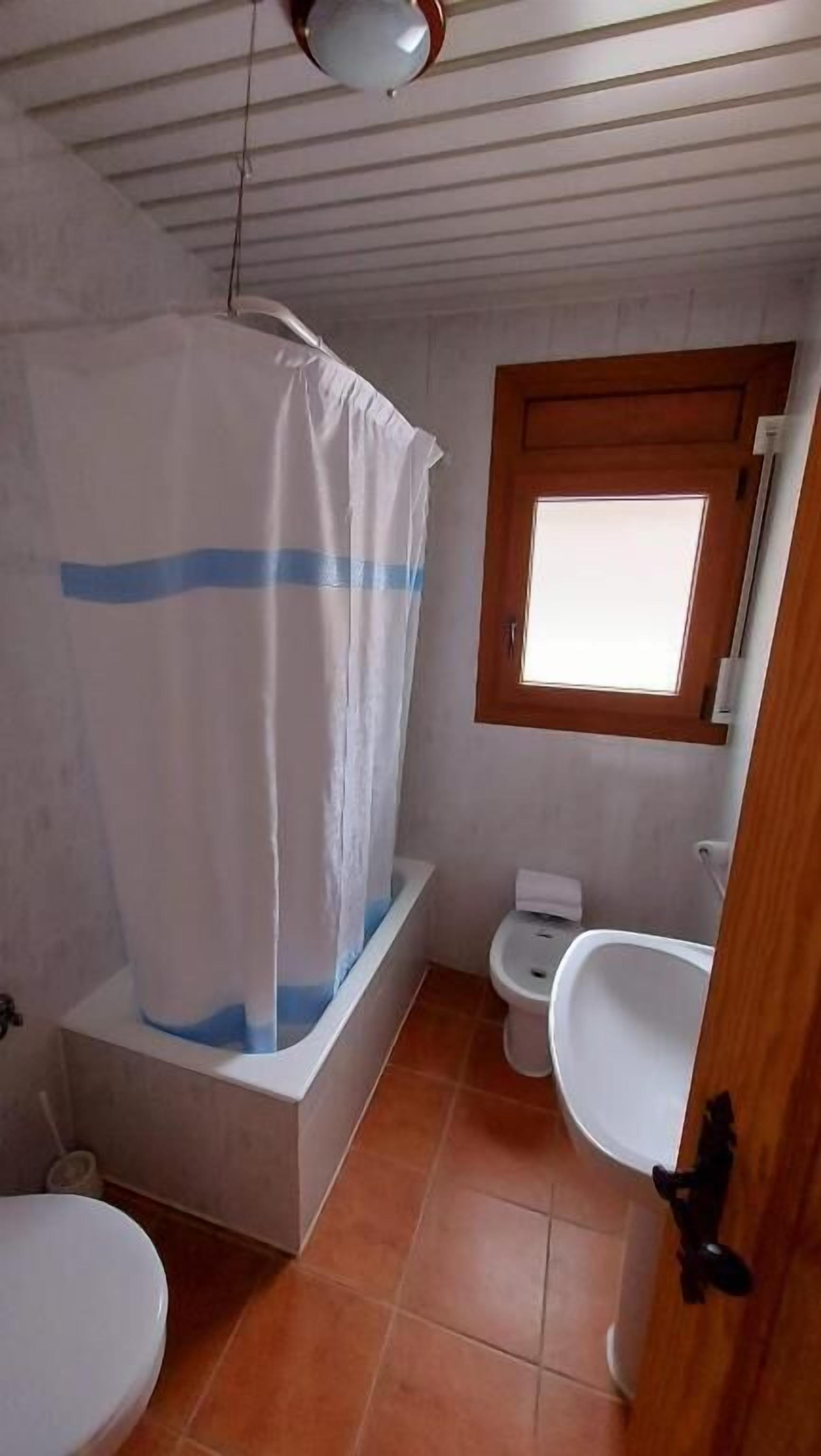 A bathroom with a shower, toilet, and sink.