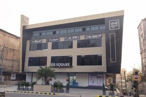 A modern building with multiple storefronts, including 'UB SQUARE' and 'De Homes.'