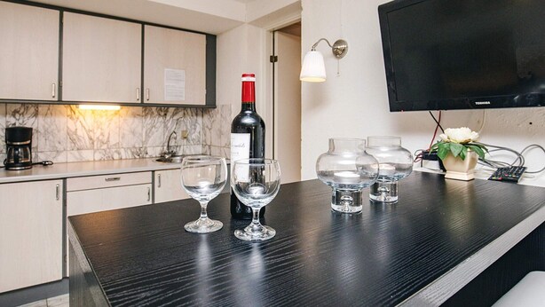 A kitchen with a marble backsplash, a wine bottle, and glasses on the counter. - 4 Person Holiday Home in Brovst (Brovst)