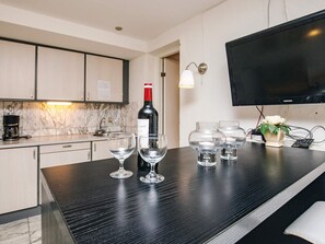 A kitchen with a marble backsplash, a wine bottle, and glasses on the counter. - 4 Person Holiday Home in Brovst (Brovst)