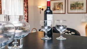 A bottle of wine, two empty wine glasses, and a glass decanter on a table. - 4 Person Holiday Home in Brovst (Brovst)