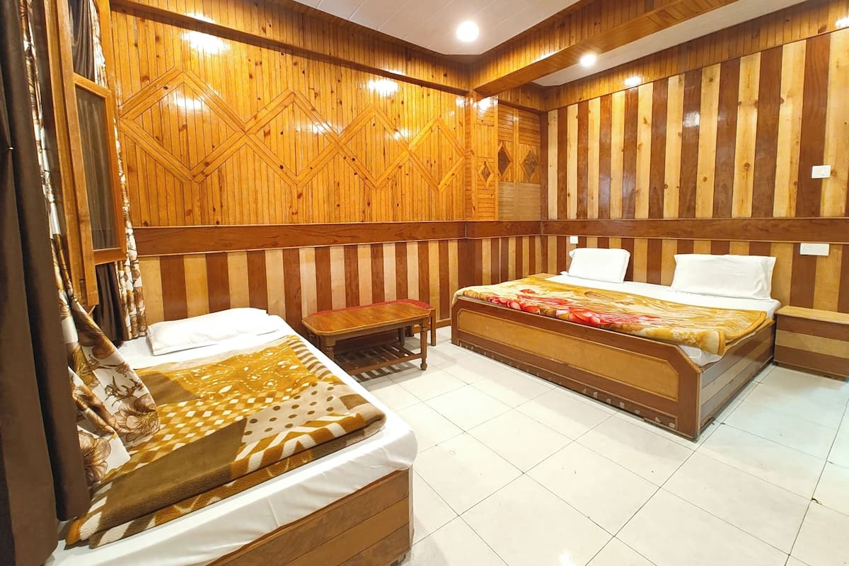 Ein Zimmer mit zwei Betten, einer Bank, Holzvertäfelung und Fliesenboden.