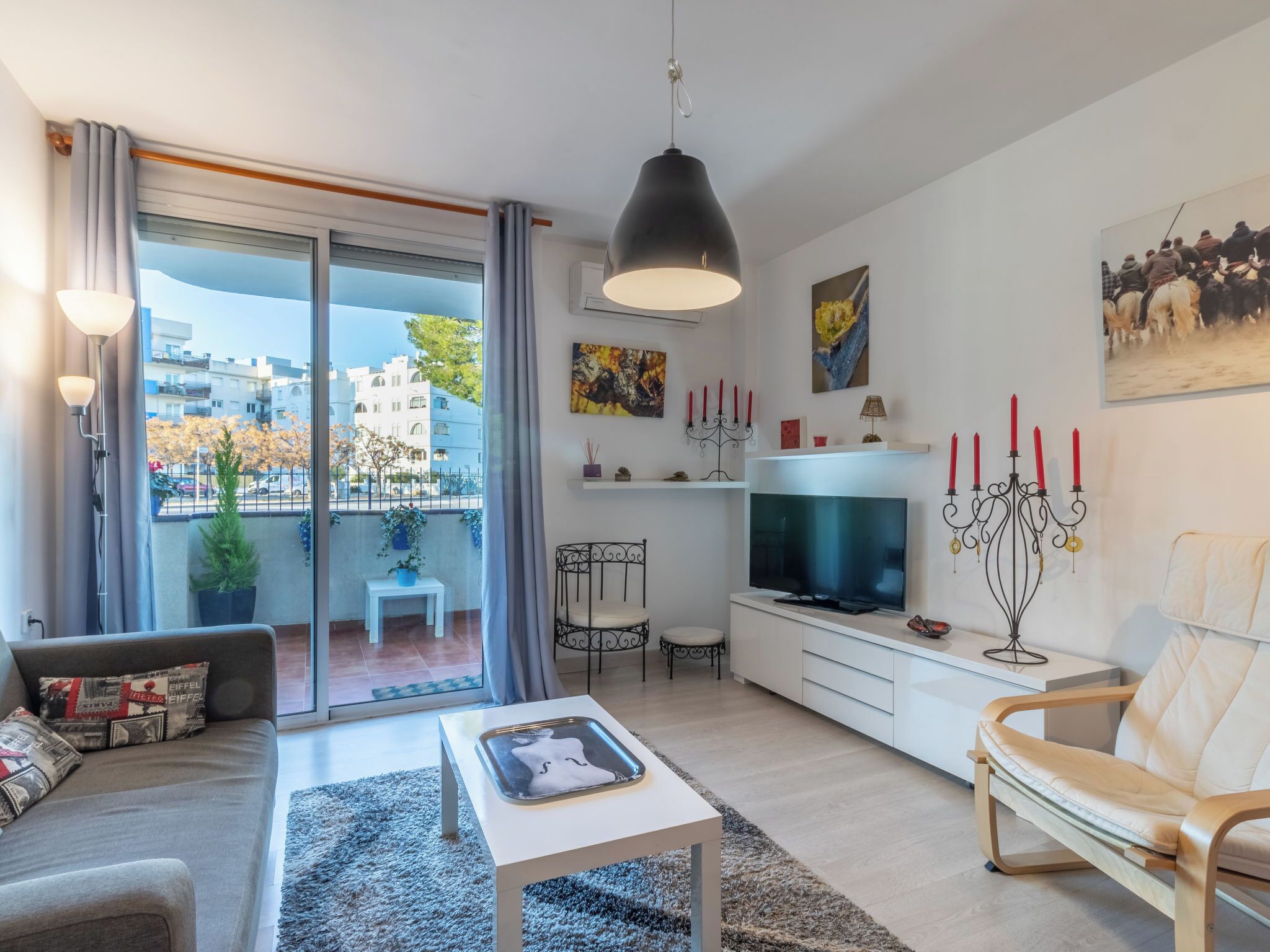 A modern living room with a sofa, a coffee table, a TV, and a dining area.
