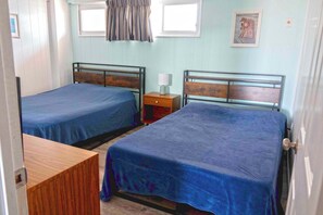 A room with two beds, a nightstand, a window, and a picture on the wall. - Cute, spacious 1-bedroom oceanfront condo with free WiFi, an outdoor pool, and an expansive balcony located midtown! (Ocean City)