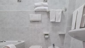 Une salle de bain équipée de toilettes, d’un bidet et d’une baignoire.