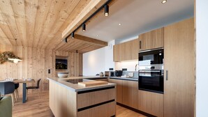 Una cocina moderna con armarios de madera, una isla central y electrodomésticos integrados.