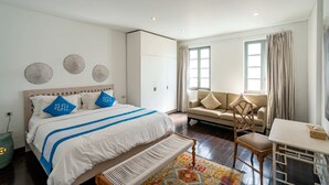 Una camera da letto con un letto, una sedia, un tavolo e una finestra.