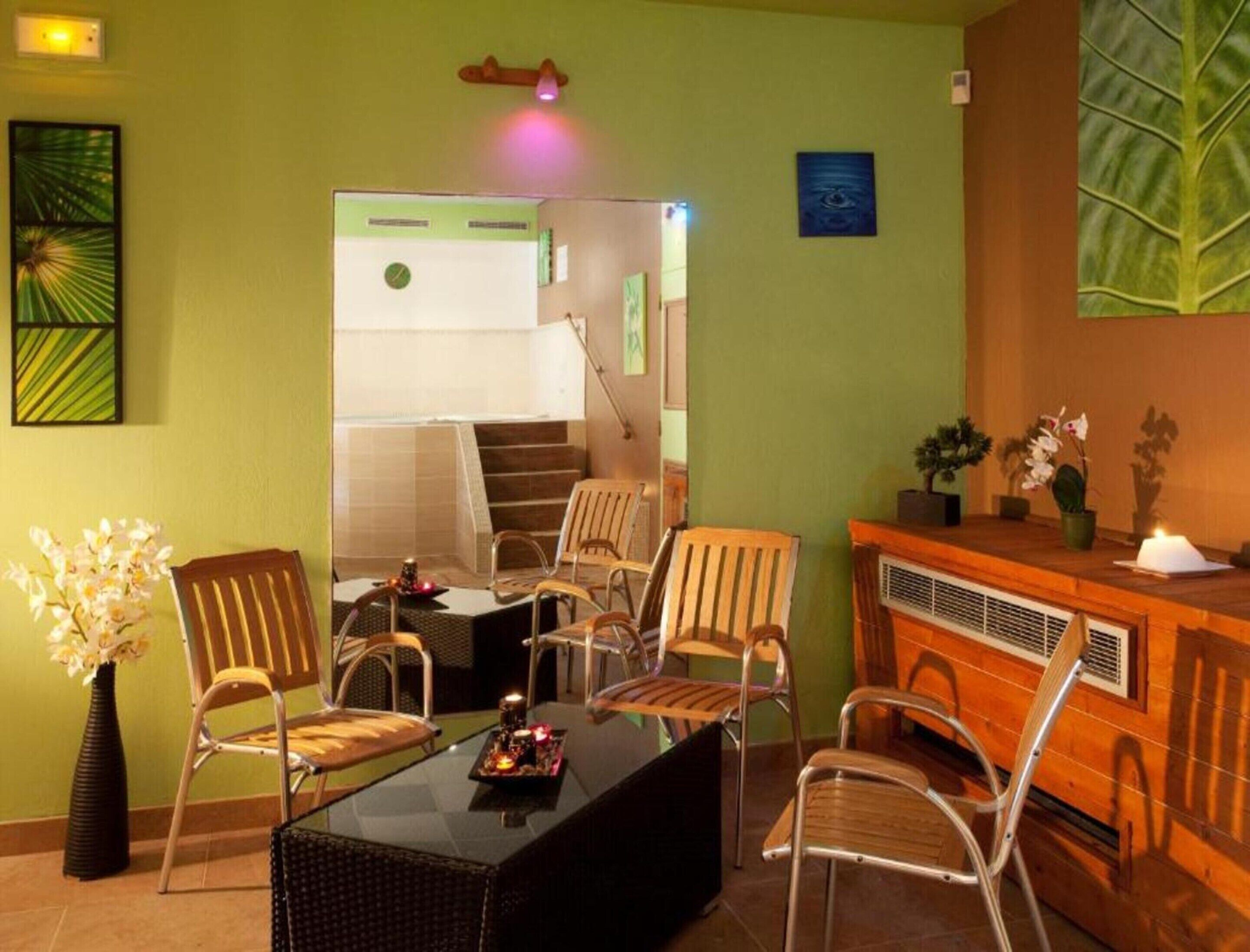 Una habitación con zona de estar, chimenea y escalera que lleva a un nivel superior.