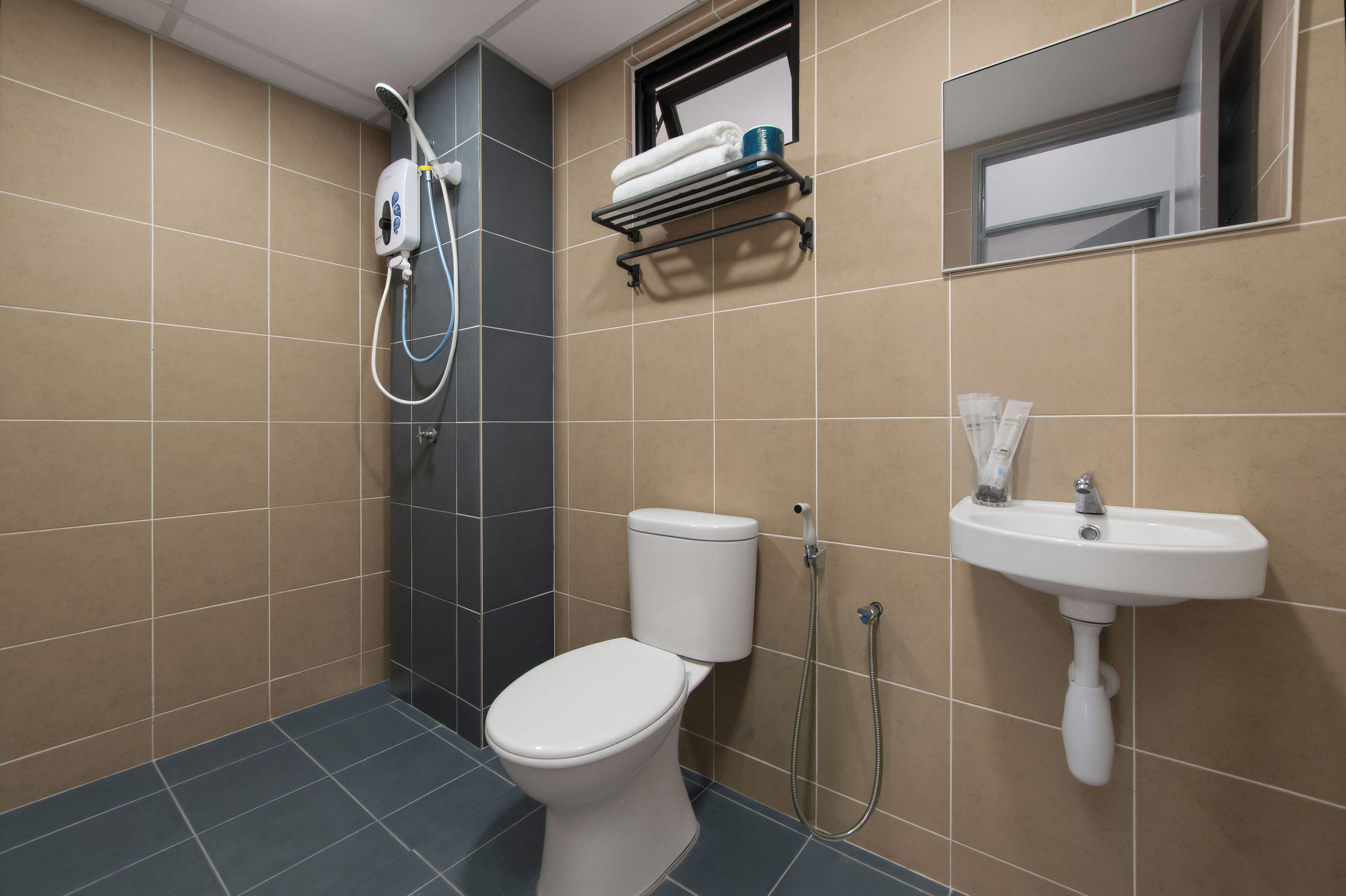 A bathroom with a toilet, a sink, a shower, and a towel rack.