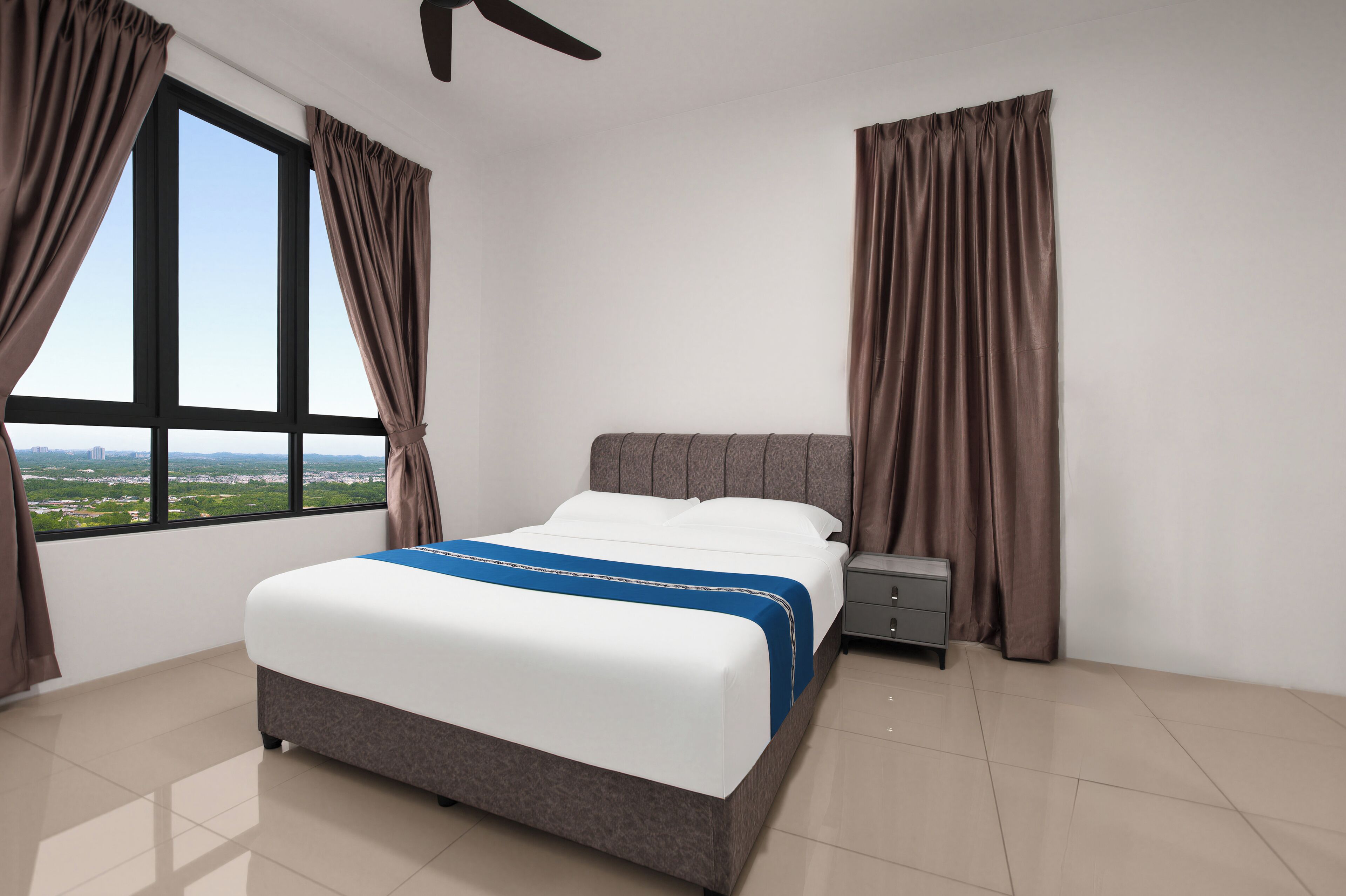 A bedroom with a bed, curtains, a nightstand, and a view through a window.