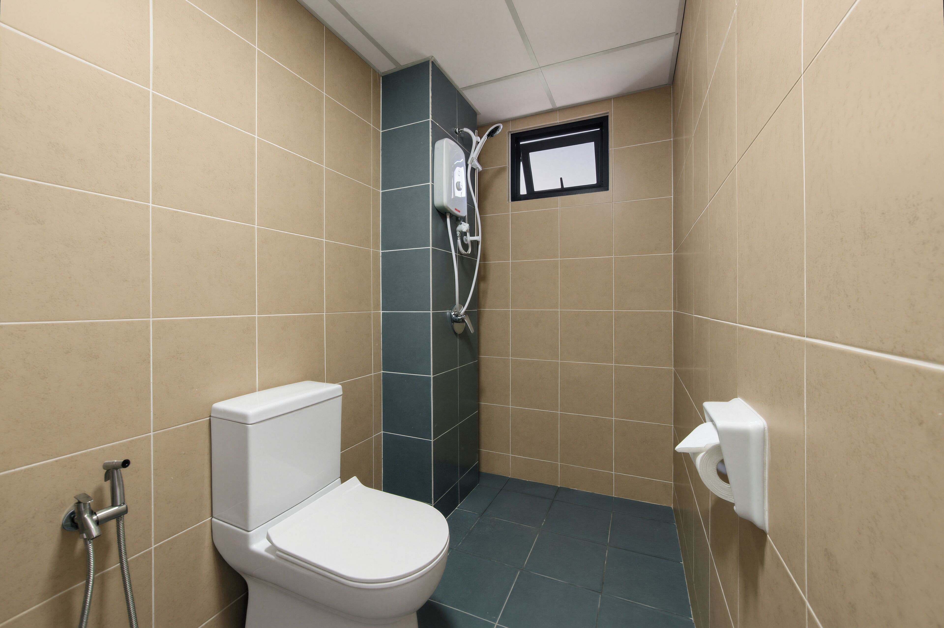 A small bathroom with a toilet, a shower, and a window.