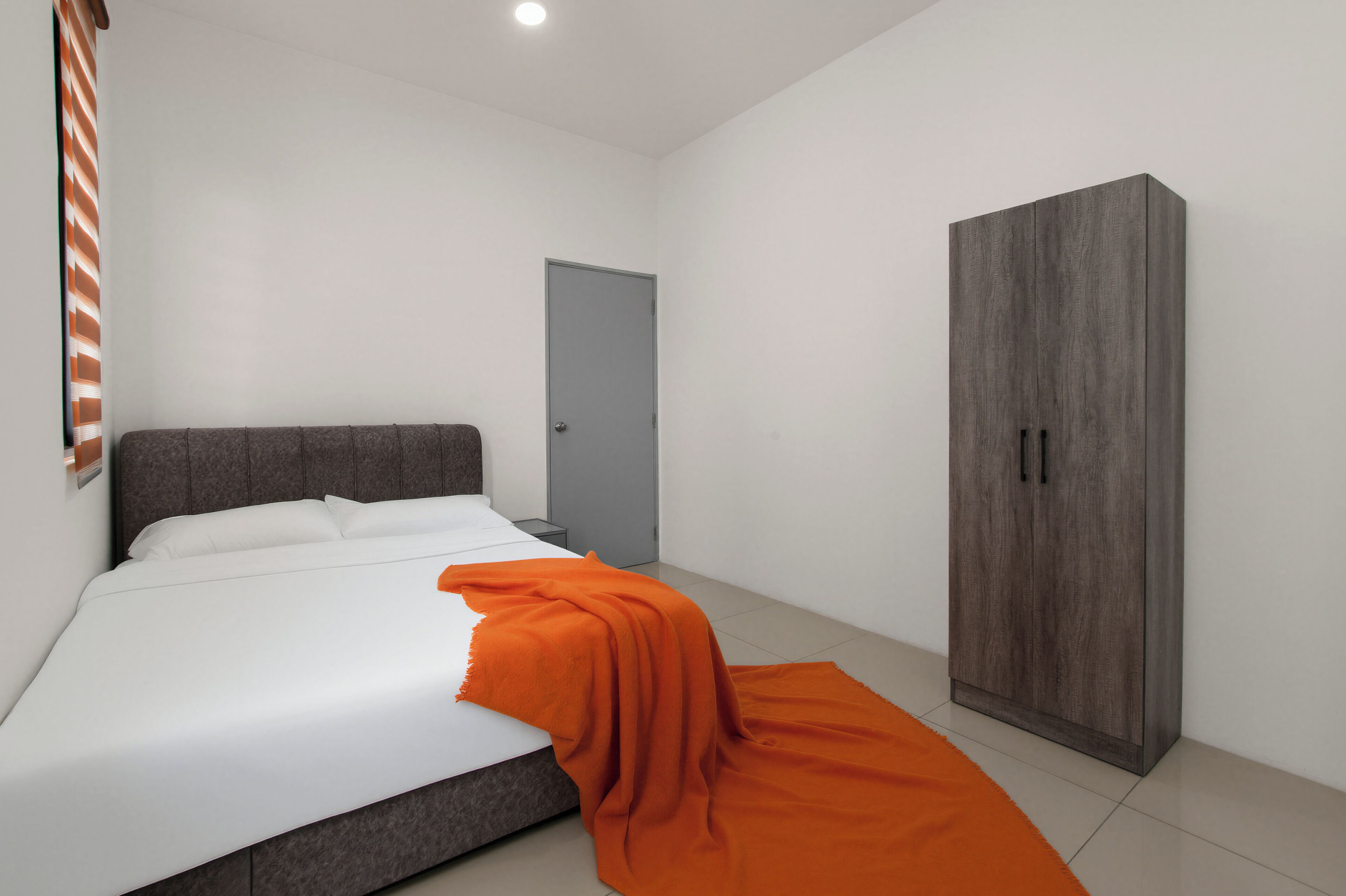 Un dormitorio con cama, armario, puerta y ventana con persianas.
