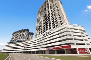 A multi-story hotel with a prominent entrance, a parking garage, and a clear sky. - KLIA Residensi---15minutes drive to KLIA (Labu)