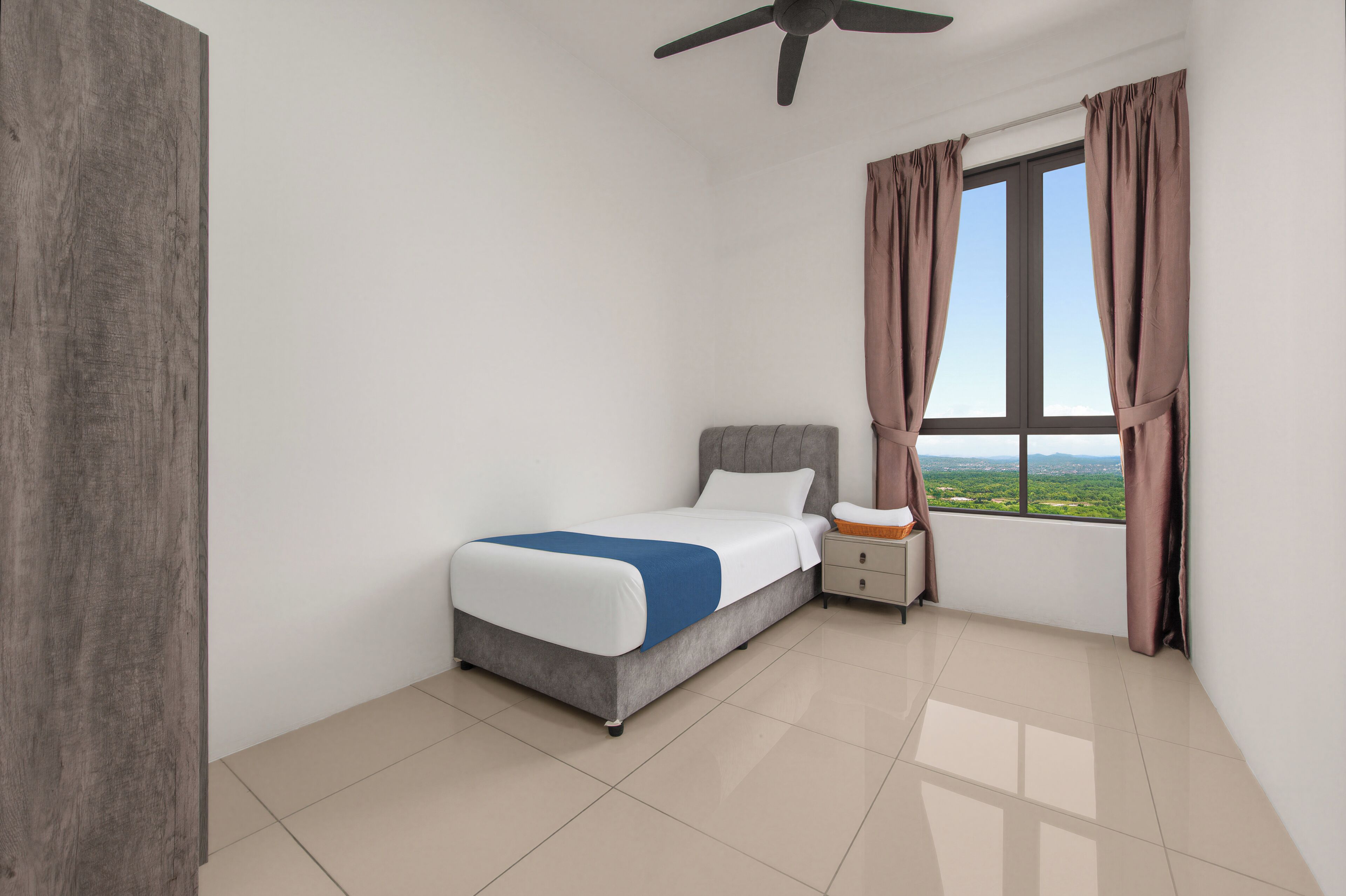 A bedroom with a bed, nightstand, window with curtains, and a ceiling fan.