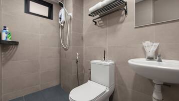 Une salle de bain moderne équipée d’un WC, d’un lavabo, d’une douchette et d’un porte-serviettes.