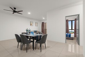 A modern dining area with a ceiling fan, a dining table with chairs, and a view of a bedroom through an open door. - KLIA Residensi---15minutes drive to KLIA (Labu)