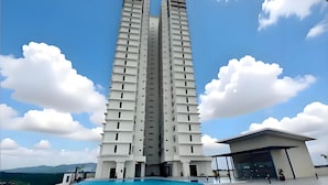 Ein Hochhaus mit Schwimmbad davor.
