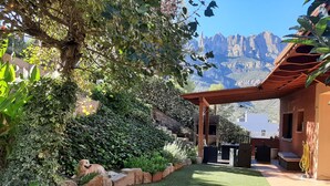 Um pátio com pérgola, mobiliário externo e vista para montanhas.