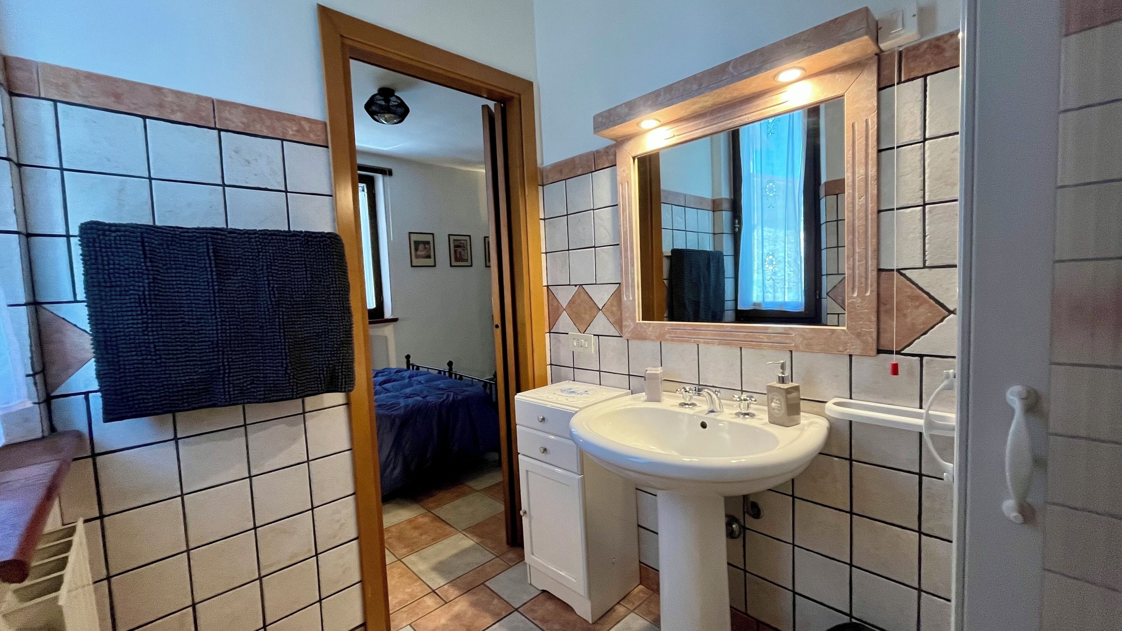 A bathroom with a sink, mirror, and tiled walls.