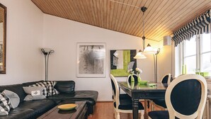 Una sala de estar con sofá, mesa de comedor, sillas y una mesa de centro.