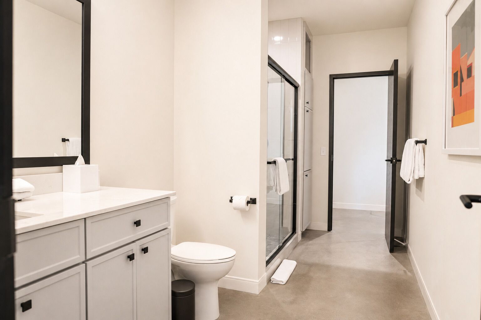 A modern bathroom with a toilet, sink, and shower.