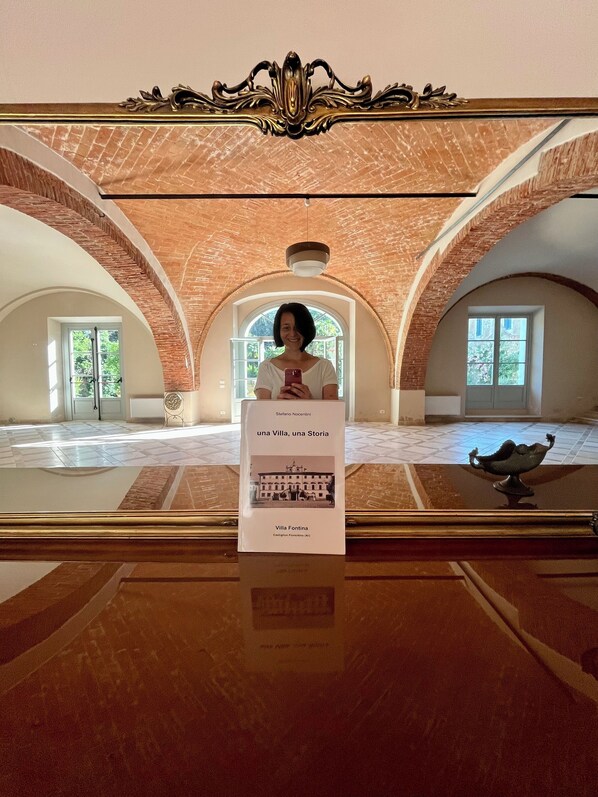 A spacious room with arched brick ceilings, a polished wooden floor, and a decorative mirror. - Agriturismo Villa La Fontina (Castiglion Fiorentino)