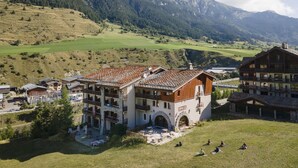 A mountain lodge with a terrace, multiple balconies, and a view of the surrounding hills and mountains. - Four-guest Hub With Sauna & Pool (Val-Cenis)