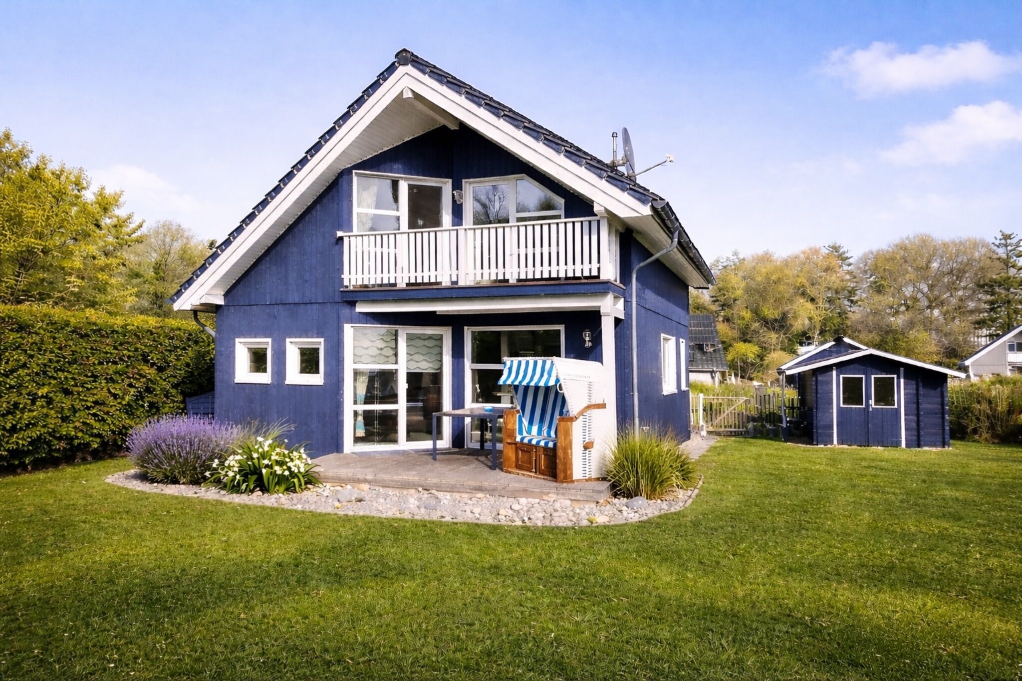 A two-story house with a balcony, a small shed, and a well-maintained lawn.