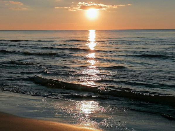 A sunset over a calm sea with gentle waves. - 4 Star Holiday Home in Lokken (Lokken)