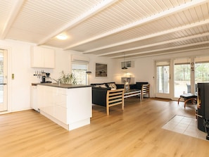 A spacious living area with a kitchen, a dining table, and a sofa. - 4 Star Holiday Home in Lokken (Lokken)