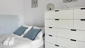 A bedroom with a bed, a white dresser, and wall art. - Malila Apartments City Center Pawia 34 (Kraków)
